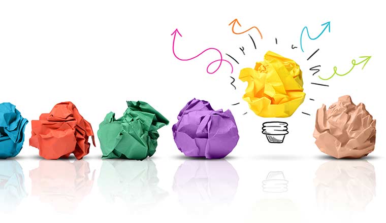 Ideas concept with balls of paper and one as a lightbulb