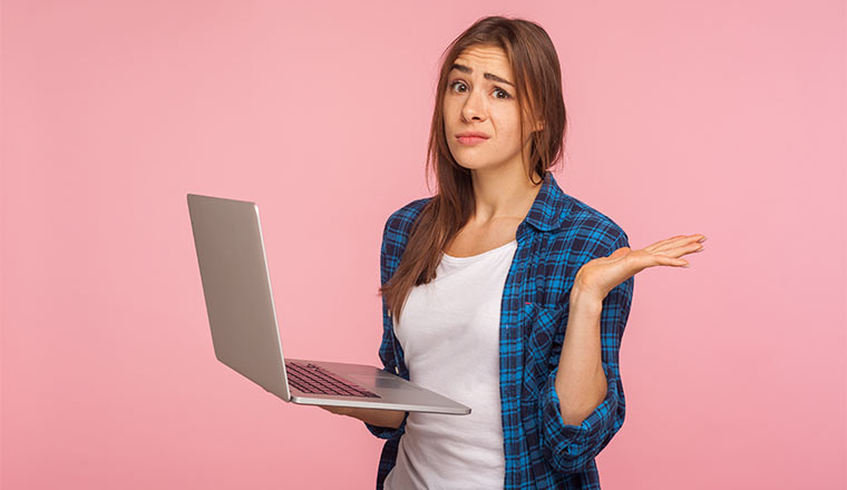 A photo of a frustrated person holding a laptop