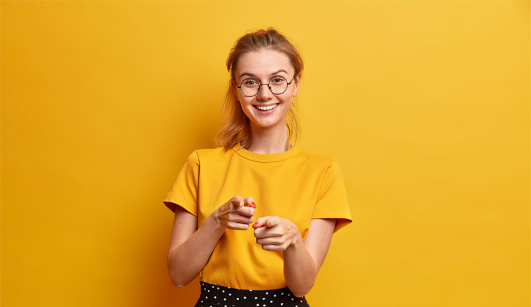 A picture of a young woman pointing at the camera