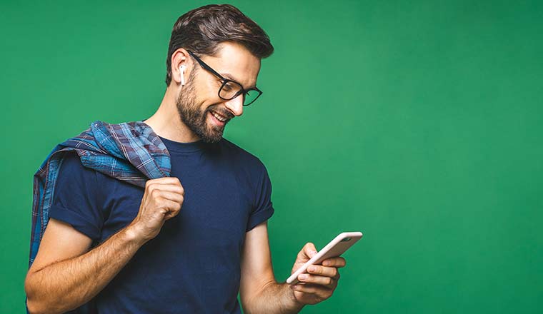 Smiling person holding smart phone and looking at it