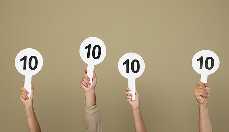 Panel of judges holding signs with highest score