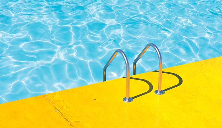 Grab bars ladder in the blue swimming pool