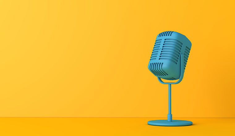 Vintage style microphone against a plain bright yellow background