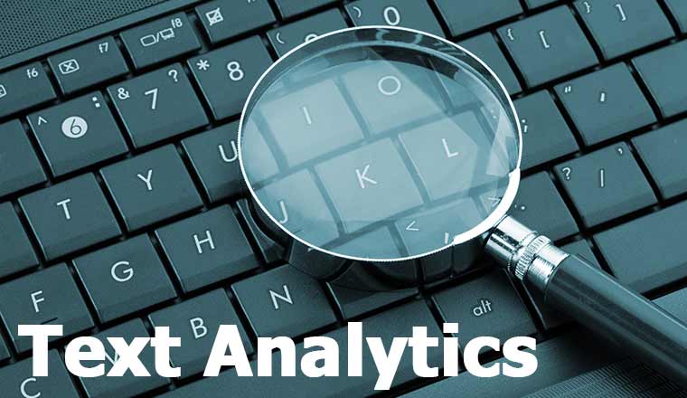 Magnifying glass on laptop with the words text analytics