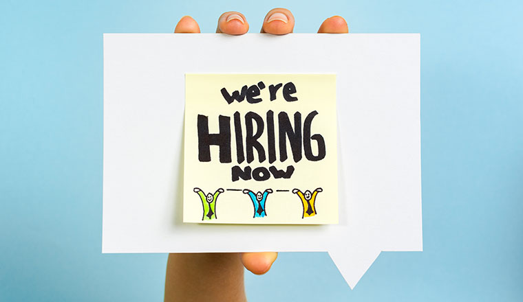 A note saying we are hiring how on a speech bubble being held