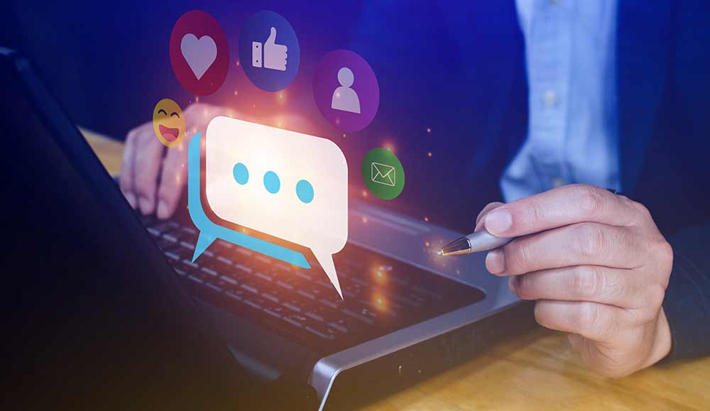 person on a laptop with social media icons and a speech bubble