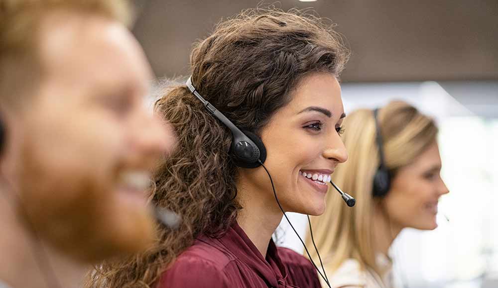 Call center operator with headset working on computer.