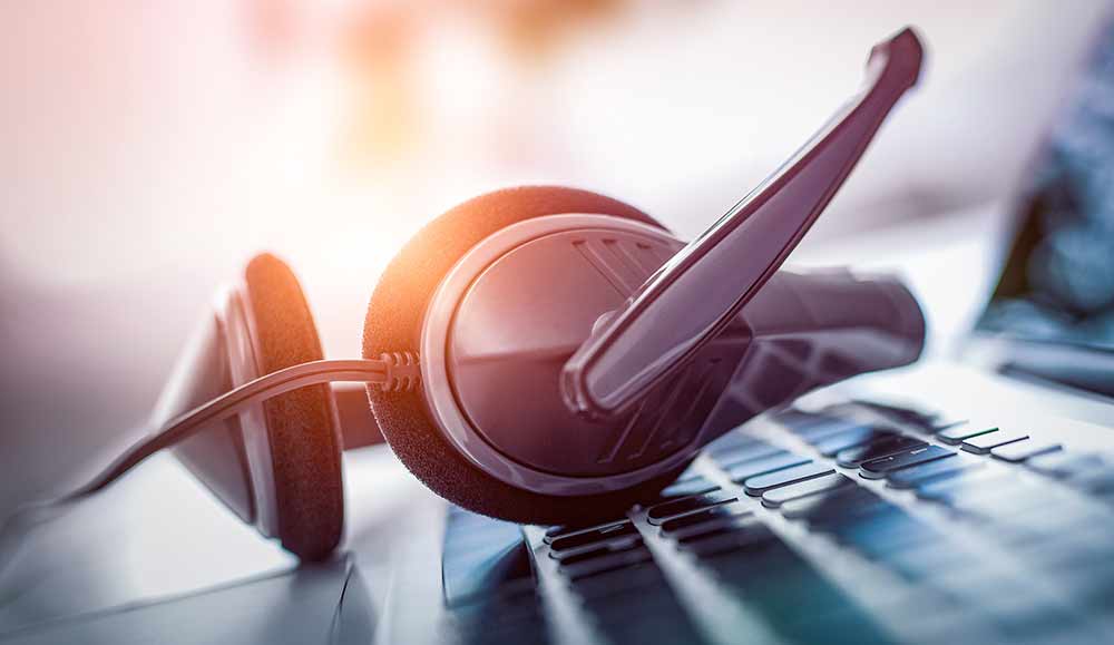VOIP headset on keyboard - call center and customer service concept