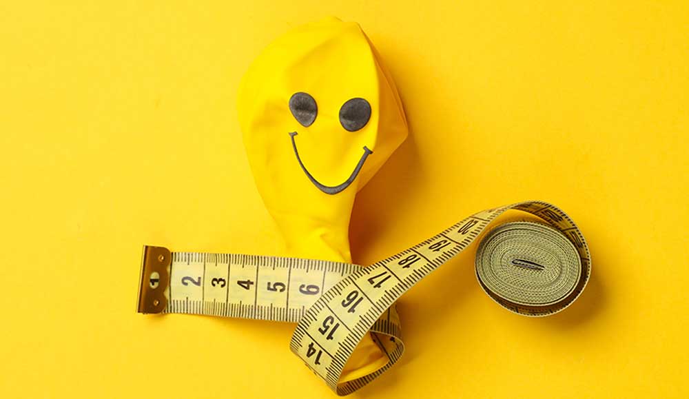 Balloon with happy face on it and measuring tape