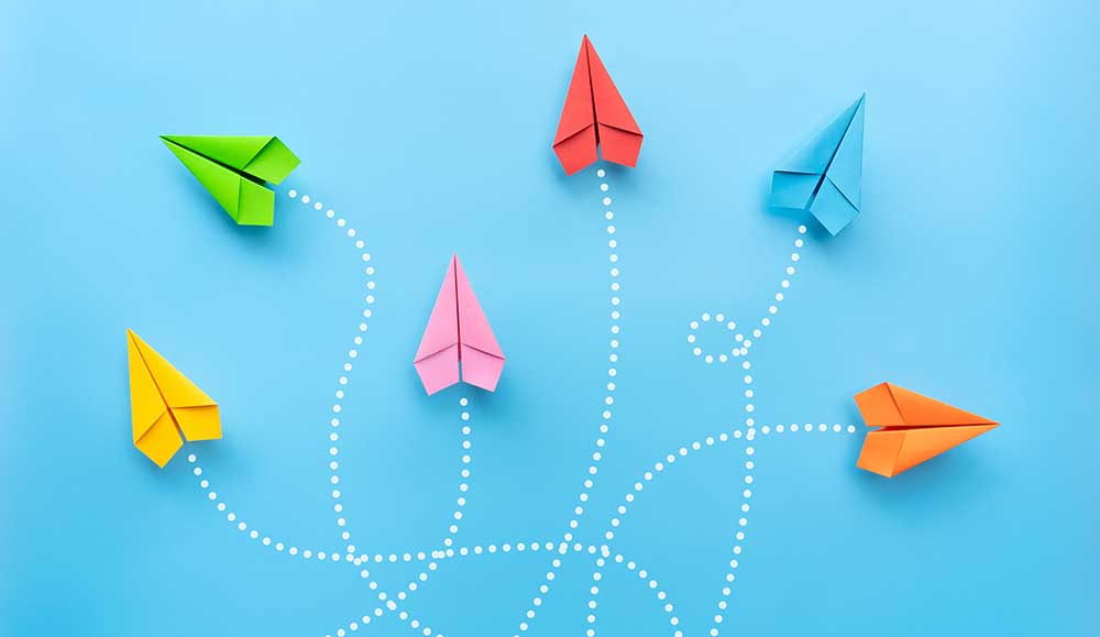 Paper planes on different routes with blue background