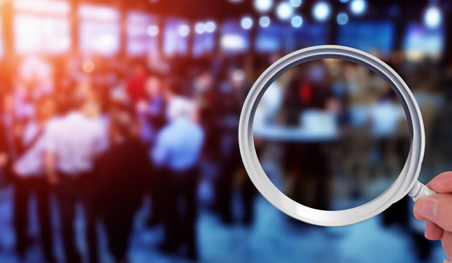 Blurred background of an event with a magnifying glass in the front