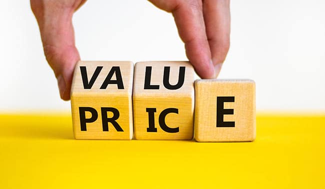 Businessman turns wooden cubes and changes the word price to value or vice versa.