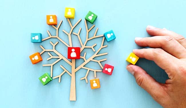 Business image of wooden tree with people icons over blue table, human resources and management concept