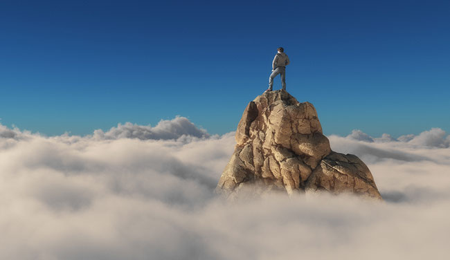 Confidence concept with person on rock above clouds