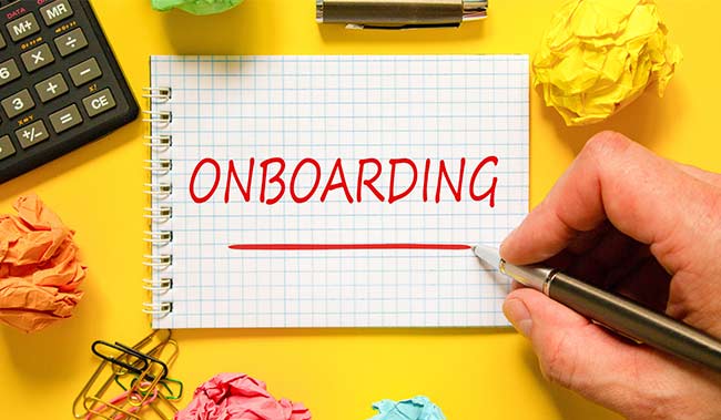 The word 'Onboarding' on a notepad