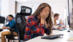 Person with head in hands at desk