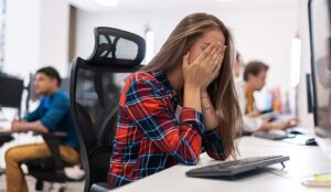 Person with head in hands at desk