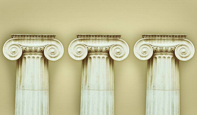 3 antique pillars stood on a yellow background