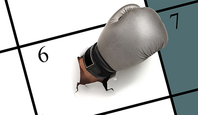 A calendar with a boxing glove breaking through it