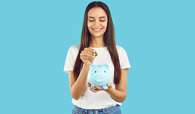 Women putting a coin in a piggy bank