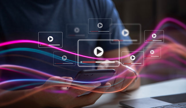 Person with phone and video screens