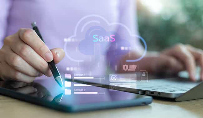 person on a laptop and tablet with a ssaas cloud