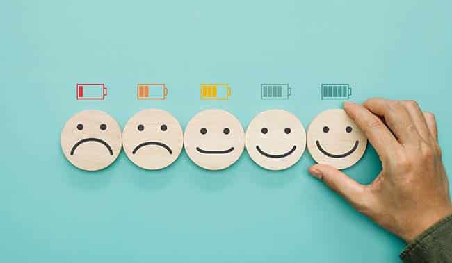 5 wooden blocks with different facial expressions from sad to happy
