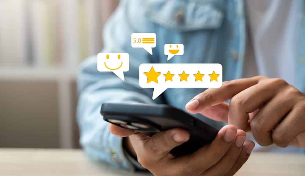 Customer service concept with person holding phone with five star rating and smiley face