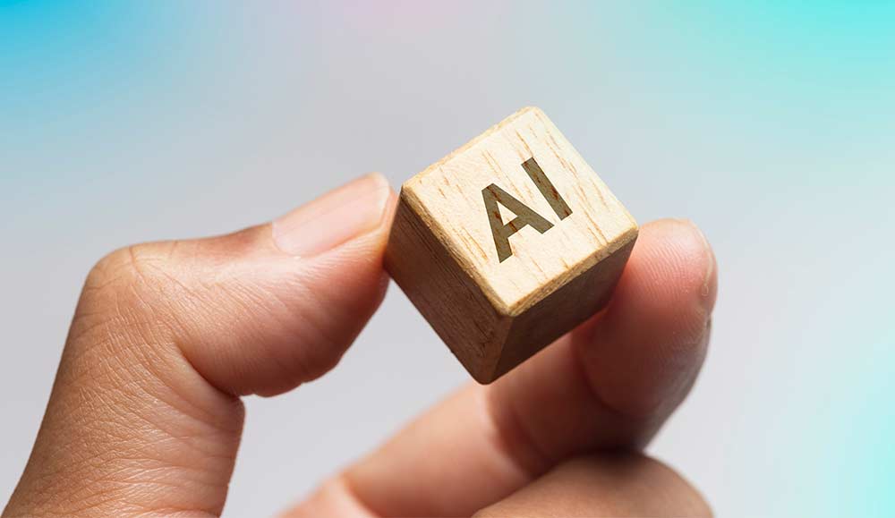 Person holding a wooden cube that says AI on it