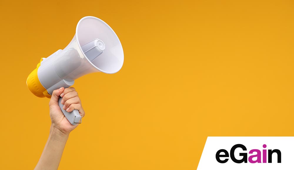 Hand holding a megaphone on colourful background - announcement concept