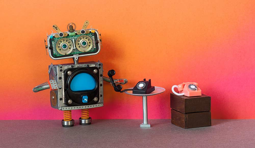 Robot holding an old phone on a table